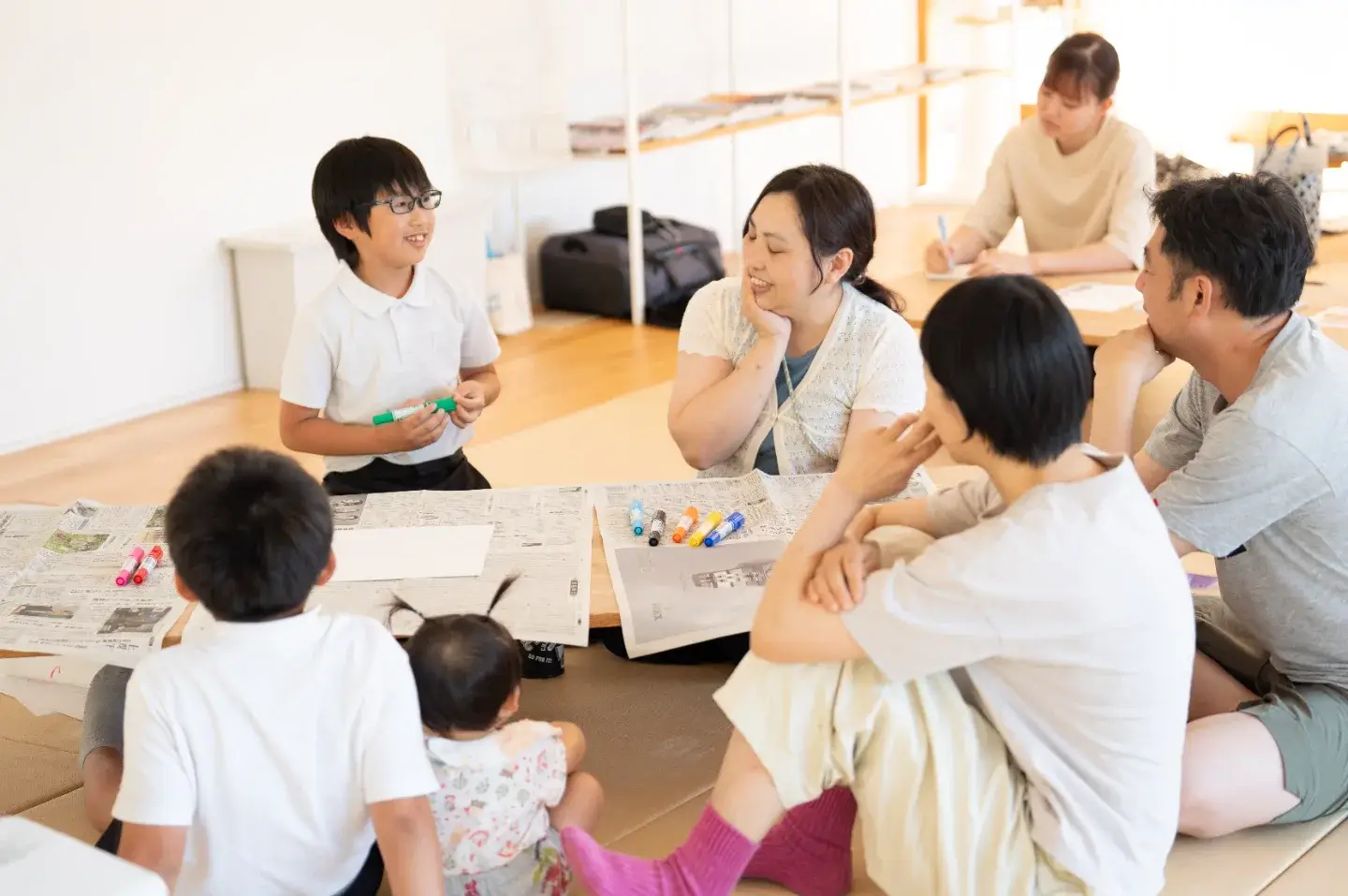 新聞紙を広げた座卓を囲み、親子で話し合う2026年6月の親子湯道教室