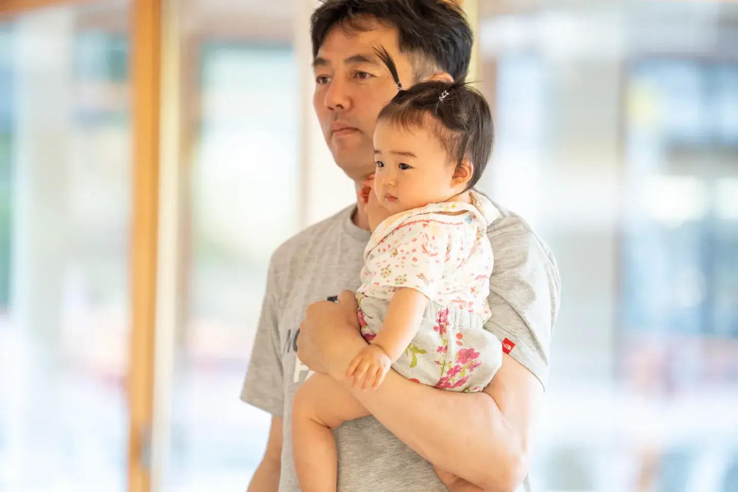 小さな子どもを抱いて話を聞く男性